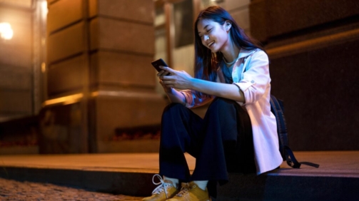 retrato-de-mulher-usando-smartphone-a-noite-nas-luzes-da-cidade